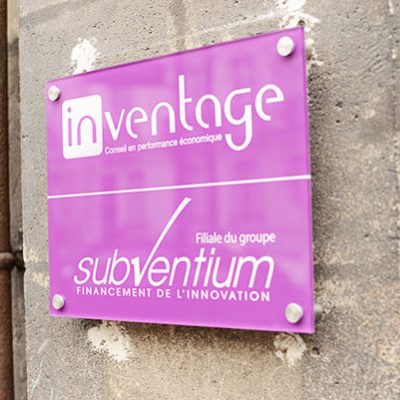 Panneau plexi rose fixé sur un mur en pierre